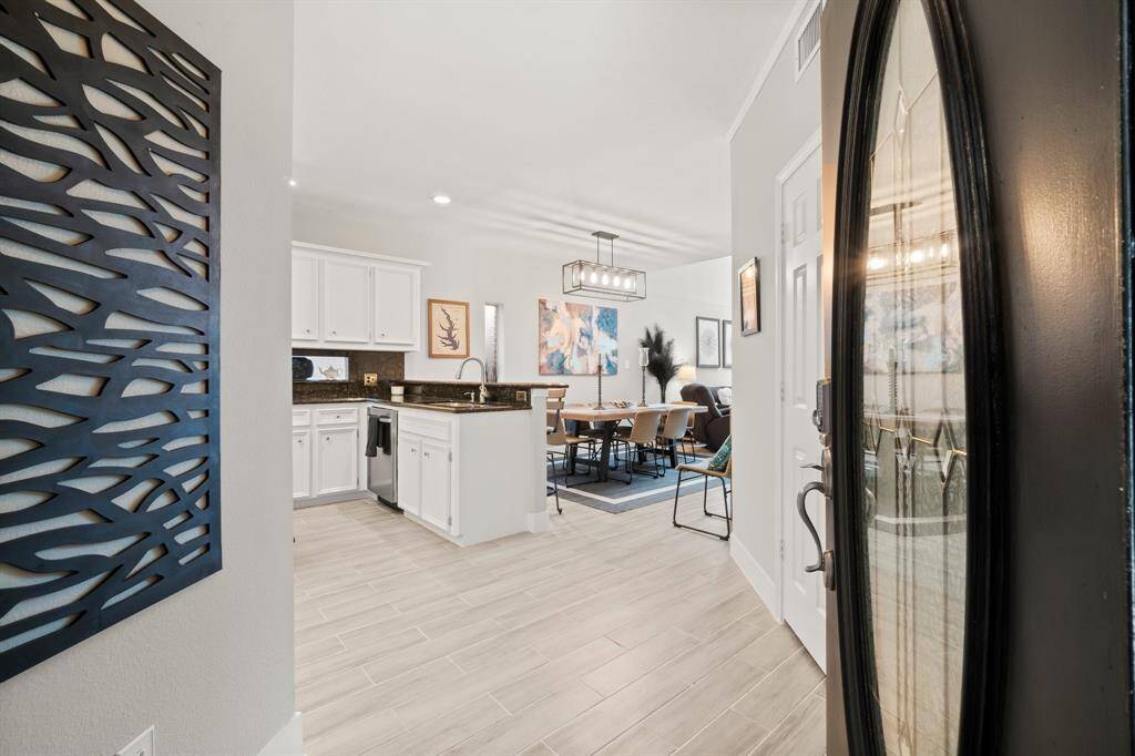 Step through the entry into this light, bright Lake side home with wood-look tile flooring, custom lighting, and tons of natural light.