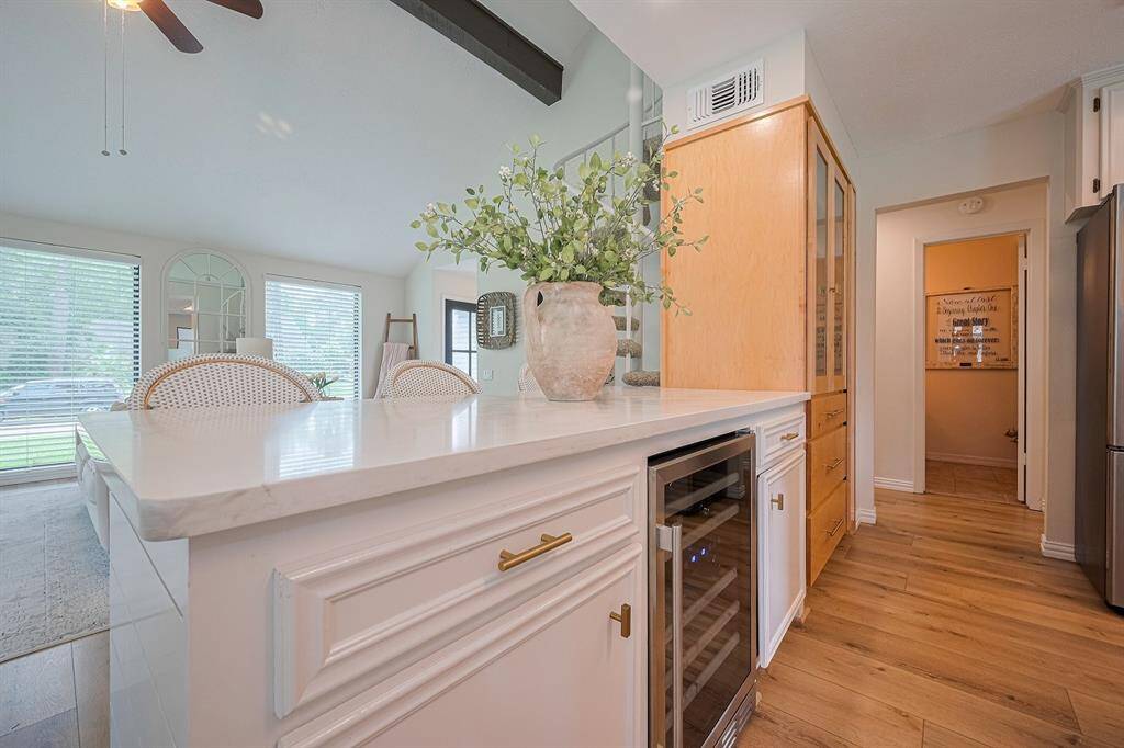 Breakfast bar view to living room.  Features quartz countertop & wine refrigerator