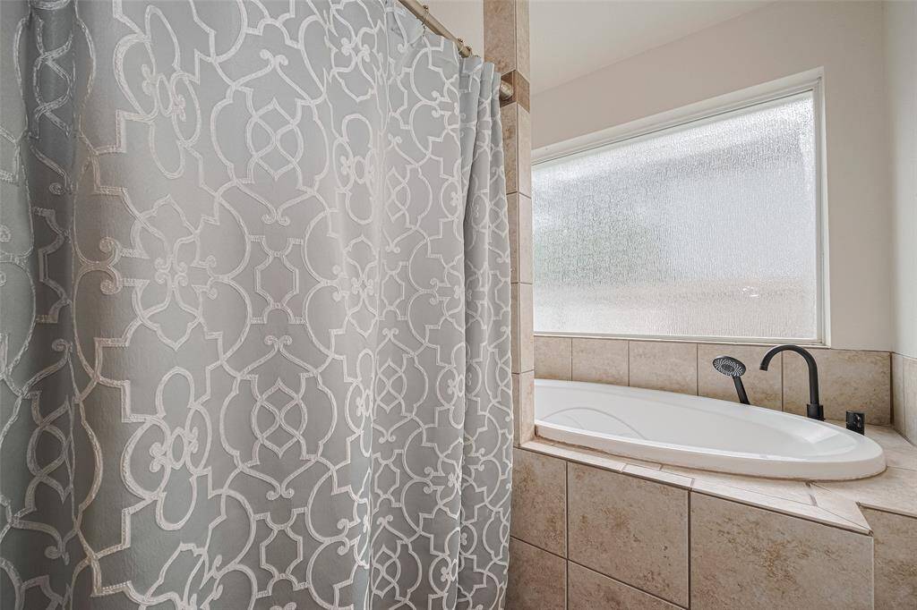 The primary bath features a jacuzzi tub and lovely shower