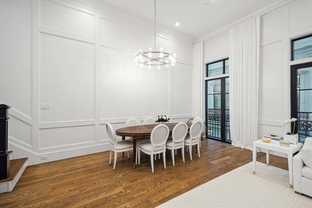 The dining area, adorned with a stunning with French doors, invites natural light to cascade in, creating a bright and sophisticated ambiance.