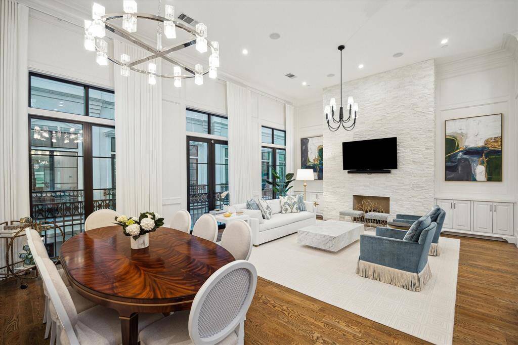 The 2nd floor's living and dining area enjoys 14' ceilings, an open-concept layout, a marble-clad powder bath, and millwork-paneled walls.