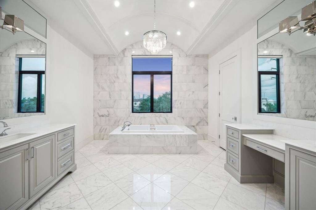 The Primary Suite bathroom beautiful marble bathroom with city views.