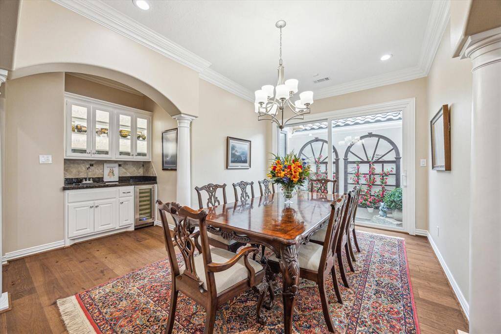 Conveniently located just off the dining room, the wet bar is elegantly designed with a wine fridge and sleek glass-front cabinetry. Take note of the stunning atrium windows, which allow natural light to flood the space.