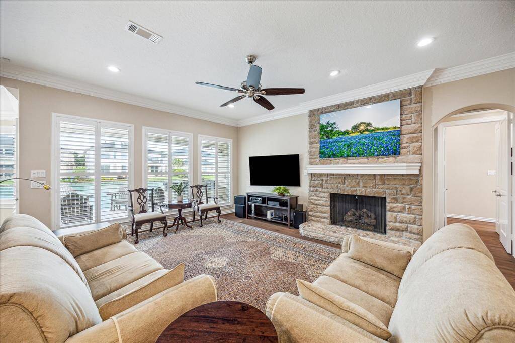 The living room features a stunning gas-log fireplace, framed by a brick surround and a rich wood mantle, creating a warm and inviting focal point.