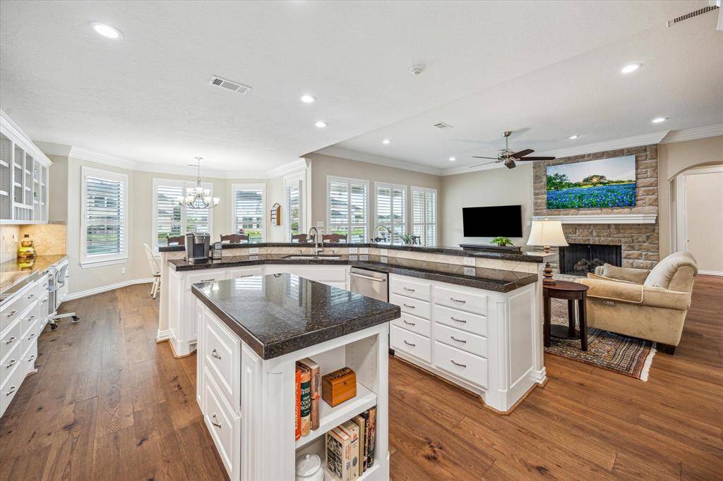 The kitchen is equipped with a 42" Sub-Zero flush-mounted refrigerator/freezer with custom panels, a professional-grade Wolf gas cooktop, double ovens, and a custom pantry.