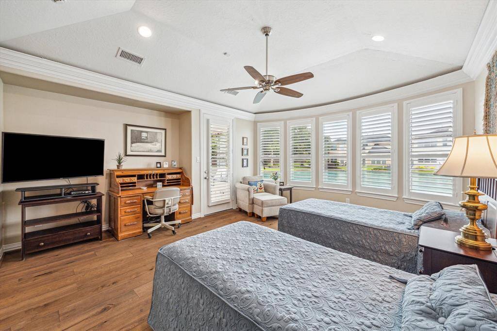 The spacious primary bedroom showcases stunning lake views and offers room for a desk and sitting area, along with direct access to the back patio for seamless indoor-outdoor living.