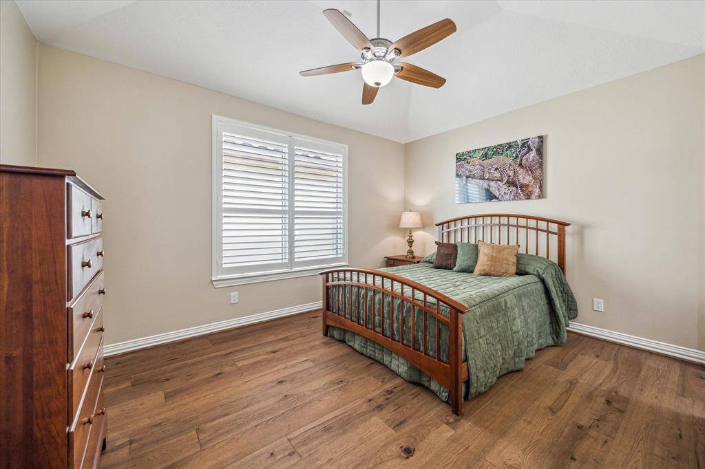 The secondary bedroom features a ceiling fan, a large window that fills the space with natural light, and its own en-suite full bath.