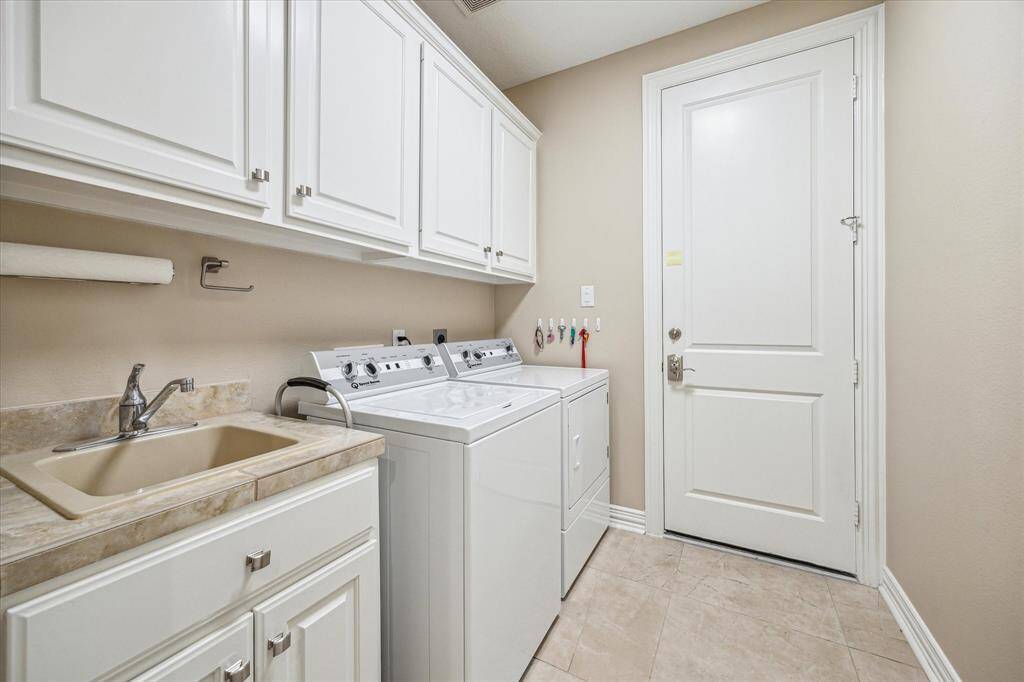 The utility room, equipped with cabinetry and a sink, provides convenient access to the garage, offering both functionality and ease.