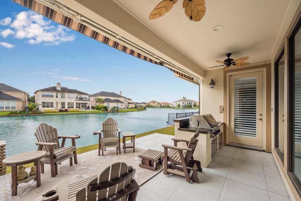 The fantastic patio is equipped with a remote-controlled awning featuring automatic high-wind retraction, an outdoor kitchen, and two ceiling fans, creating an ideal space for year-round outdoor living and entertaining.