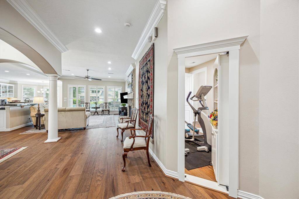 A cleverly concealed door opens to reveal a versatile flex room, currently utilized as a home gym, offering both functionality and a touch of intrigue.