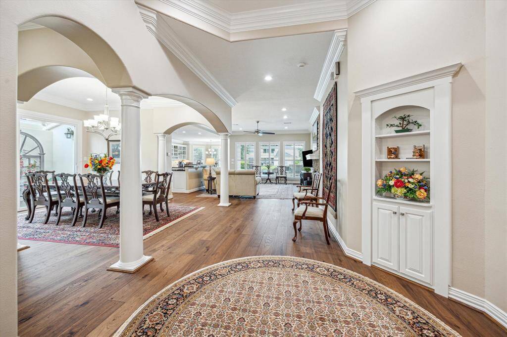 The home showcases beautiful architectural details, including graceful archways, elegant crown molding, custom built-in cabinetry, and stunning LifeCore engineered hardwood floors.