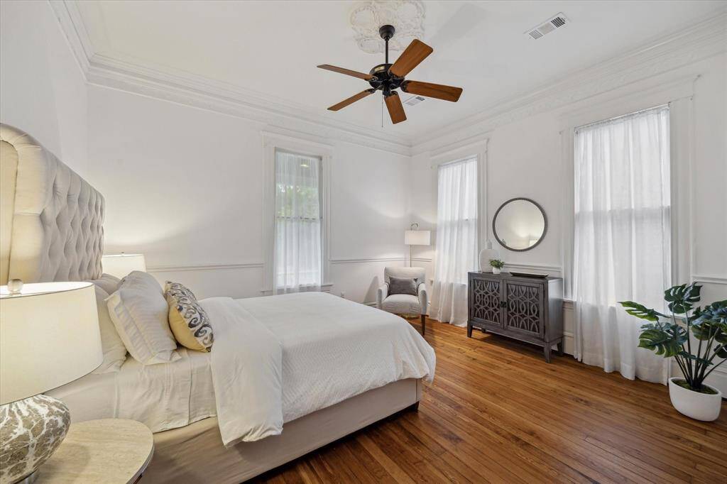 The first floor primary suite is filled with natural light and offers a peaceful view of the front yard.