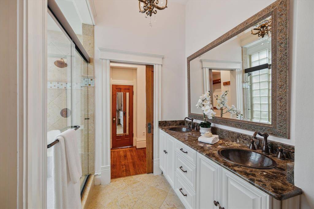 The primary bathroom includes dual sinks, a large walk-in shower, and direct access to a generous closet that connects to the laundry room.