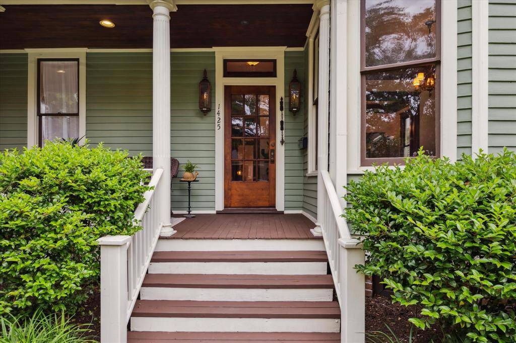 Step up to a timeless entry framed by twin gas lanterns and an original wood door.