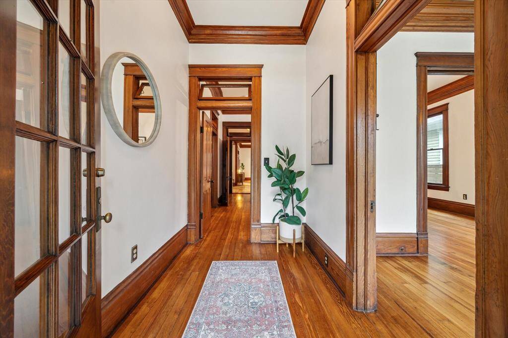 A large foyer sets the tone with rich millwork, original transoms and a view that draws you into the heart of this storied home.