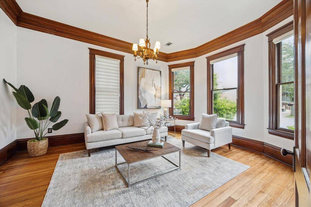 Bathed in natural light, this front living room welcomes you with soaring 12 ft ceilings and original historic windows!