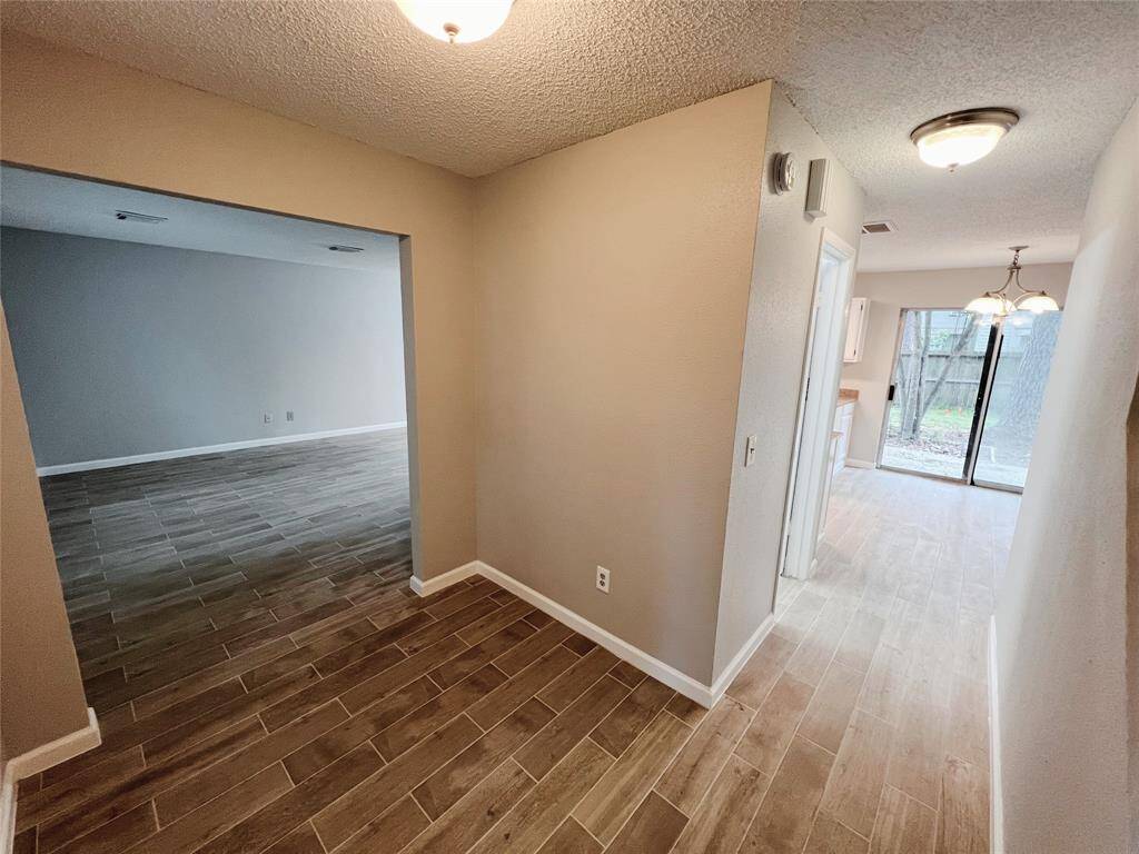 Den (left) and hallway leads to the half bathroom, kitchen and living room