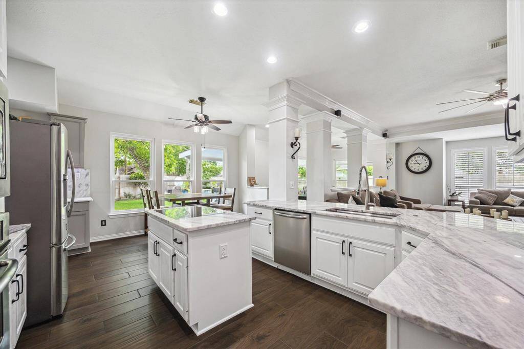 WALL OF NEW WINDOWS BATHES THE KITCHEN & DINING AREA IN NATURAL LIGHT.