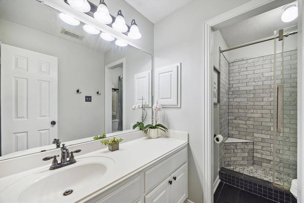 FULLY UPDATED BATH WITH DESIGNER TILE SHOWER AND MODERN FIXTURES.