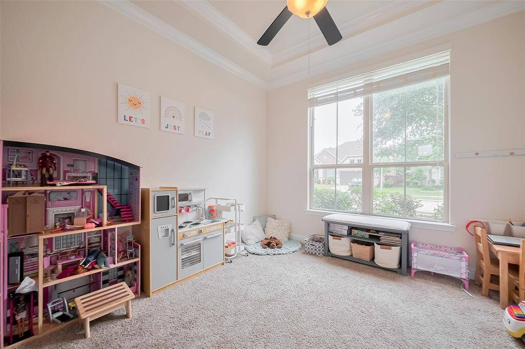 Bright and inviting playroom with large windows, soft carpet, and ample space for toys and activities. Perfect for family fun and creativity.