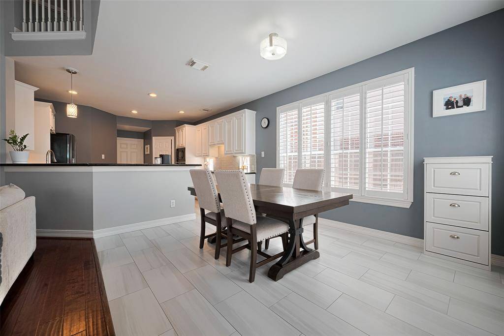 The breakfast room and kitchen feature 12"x24" ceramic tile, modern fixtures and walls of windows with shutters.