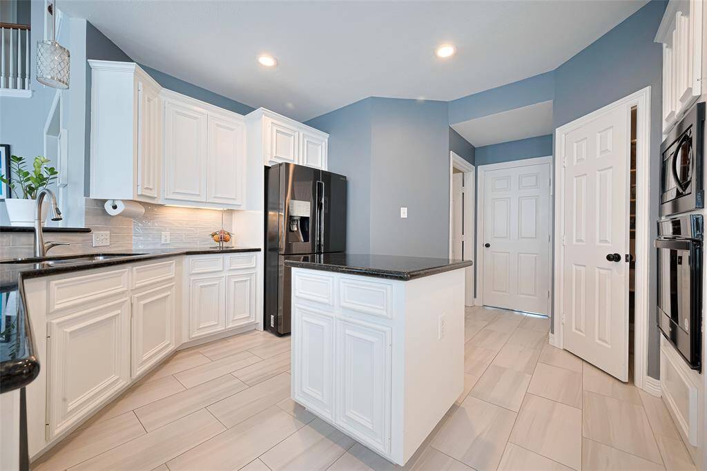 This beautiful kitchen is open bright.  It features an island and large walk-in pantry.