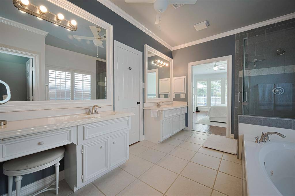 The primary bathroom has been features dual vanities, modern hardware, seamless glass shower and updated tile in the shower.