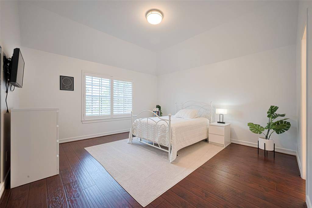 The upstairs bedroom #1 offers a rich wood-look laminate flooring, fresh paint, shutters and features a Jack & Jill bathroom.