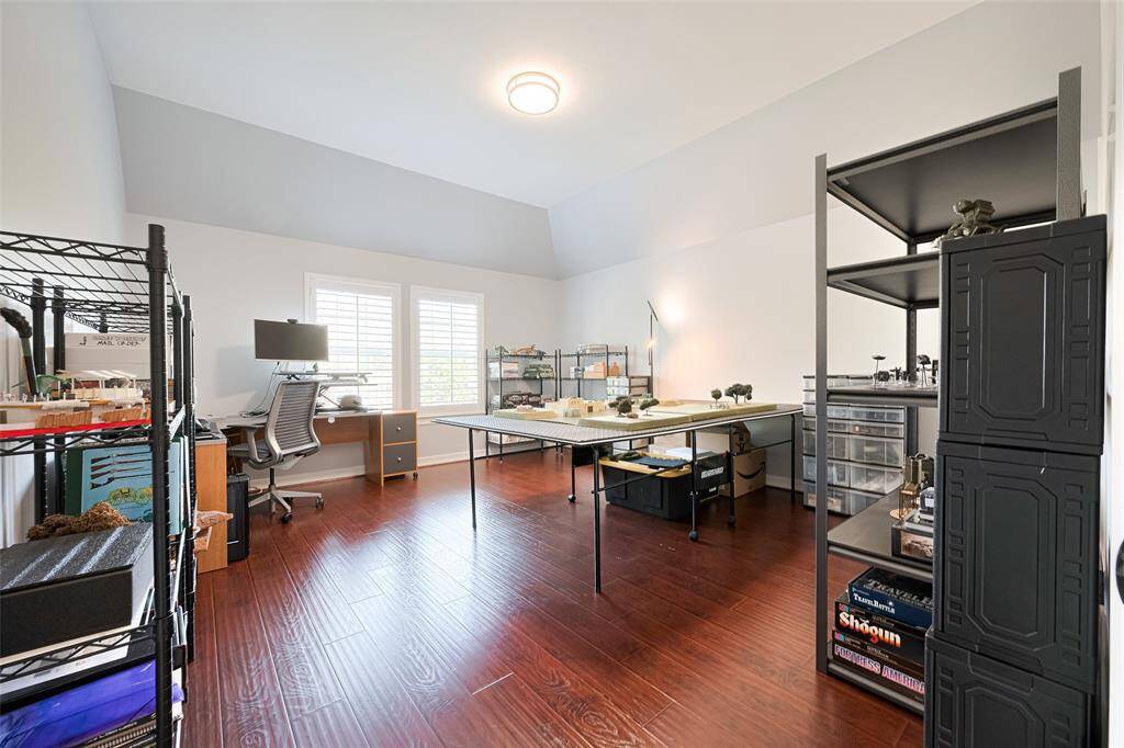 Bedroom #3 upstairs features fresh paint, high ceilings, rich wood-look laminate floors, windows with shutters and a spacious walk-in closet.