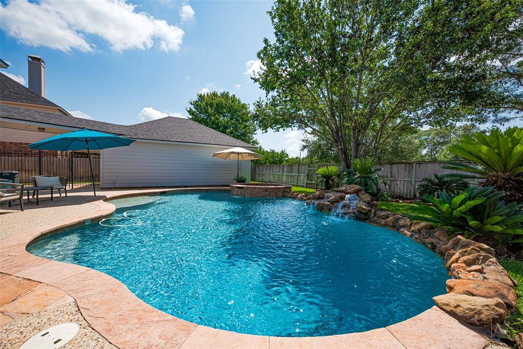 The pool features PebbleTec coating for a sleek appearance, fountain, and flagstone accents.