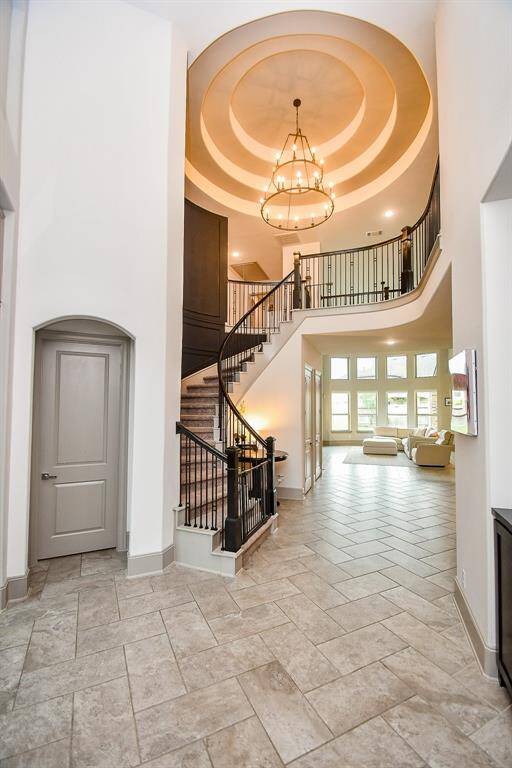 Walk into a designer home with coffered ceilings and upgraded light fixtures! Love the tile flooring!