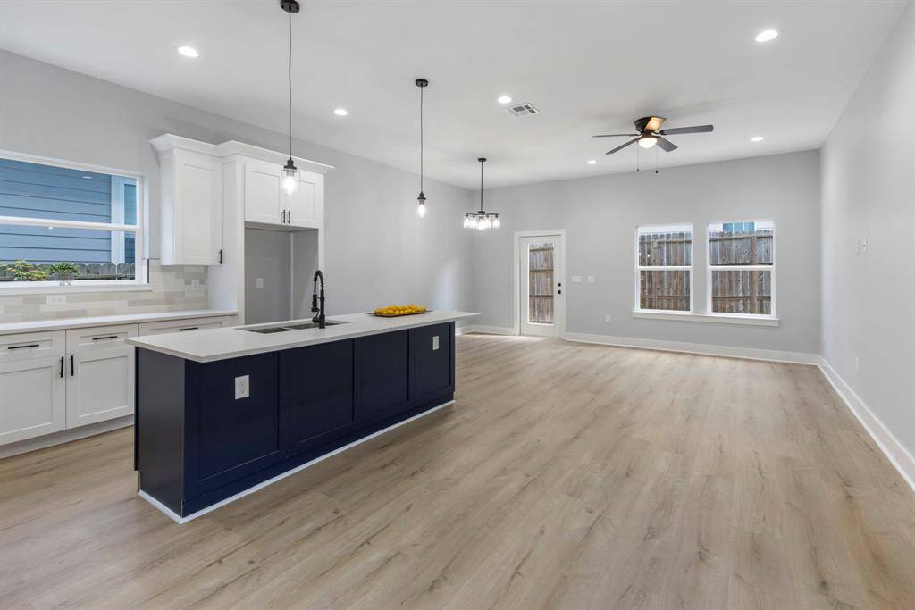 The open floor plan creates a seamless flow between the kitchen, dining, and living areas.