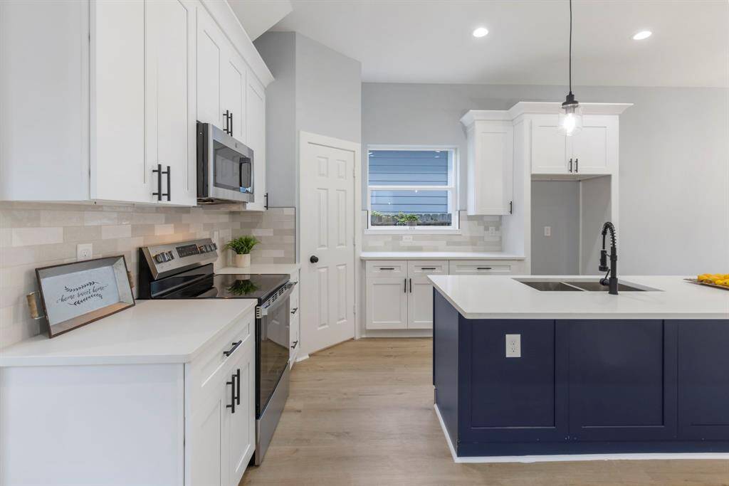 The kitchen features quartz counter tops, 42' cabinets, a large island w/sink, SS appliances, and a cozy window to enjoy the sunshine while preparing meals.