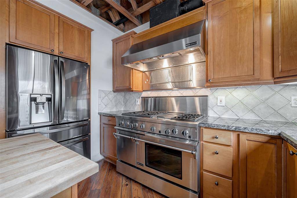 Chef's commercial grade JennAir double oven with 6 burners and a griddle along with a JennAir vent top.
