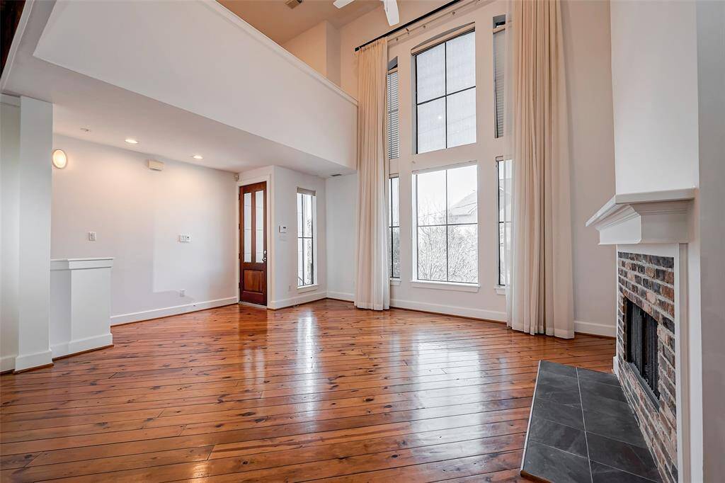 Enter to the living area (18X14) with soaring ceilings, floor to ceiling windows, fireplace and pine floors.