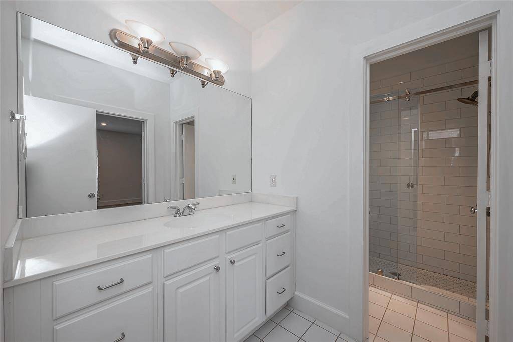 Full bath down with updated frameless glass shower.