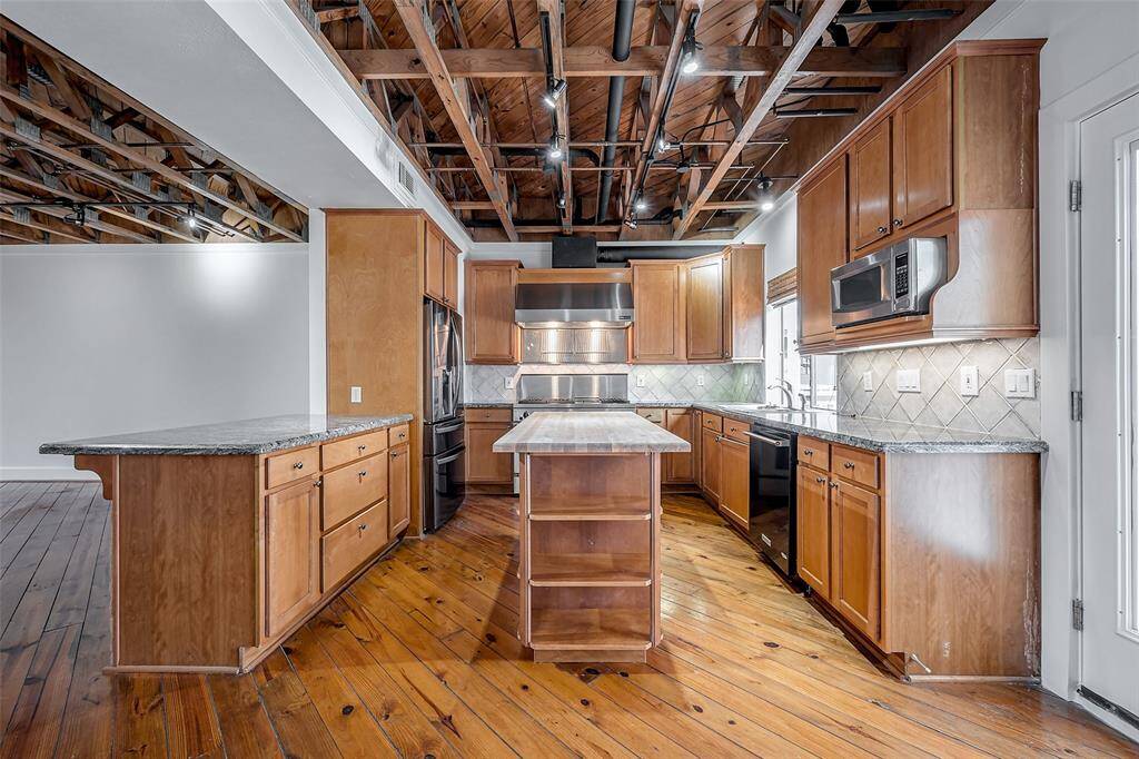 Great kitchen featuring butcher block island, pine floors and fridge included.