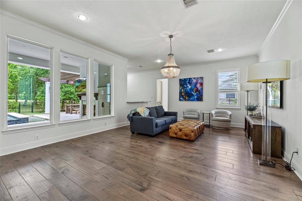Large windows overlook the backyard, providing serene views and easy access to outdoor living. The room’s open layout seamlessly connects indoor comfort with the beauty of the landscaped yard.