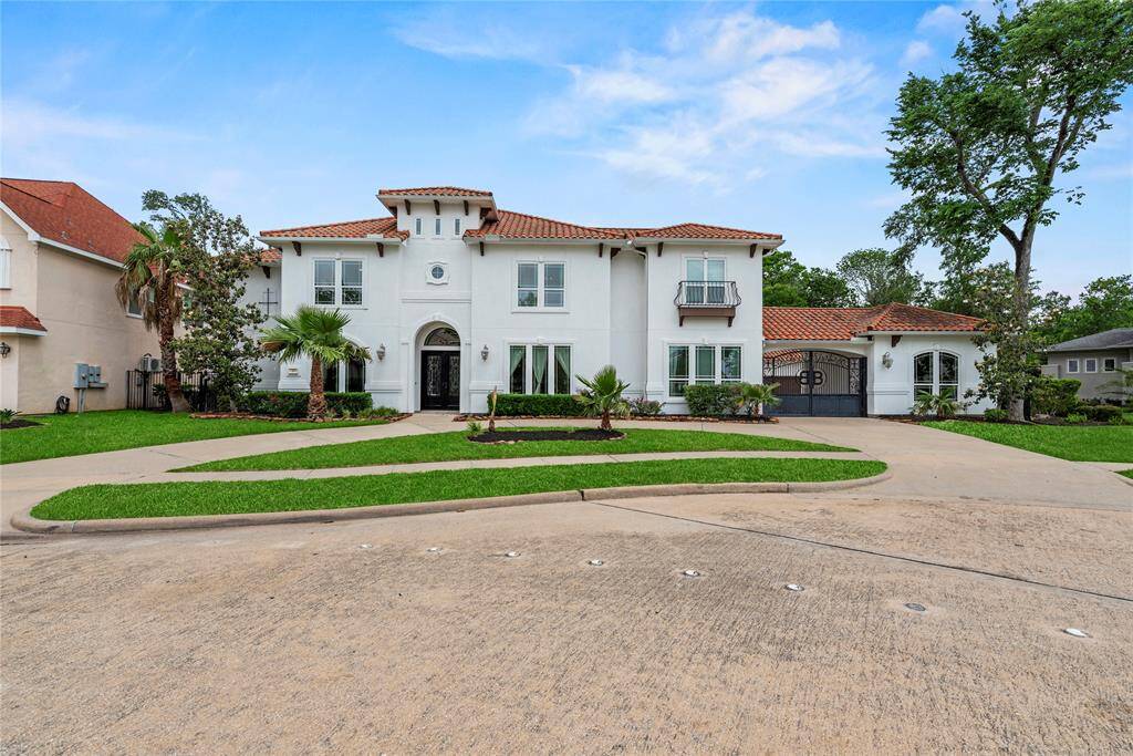 This modern Mediterranean estate, built by Sterling Classic Homes, boasts timeless elegance with a stucco exterior, tile roof, and grand arched entryways.