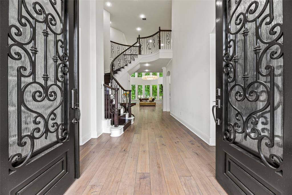 Grand and spectacular, the two-story foyer makes an impression on all your guests! White oak, wide plank floors gleam in the presence of luminous natural light, while the above light fixture adds a touch of luxury.