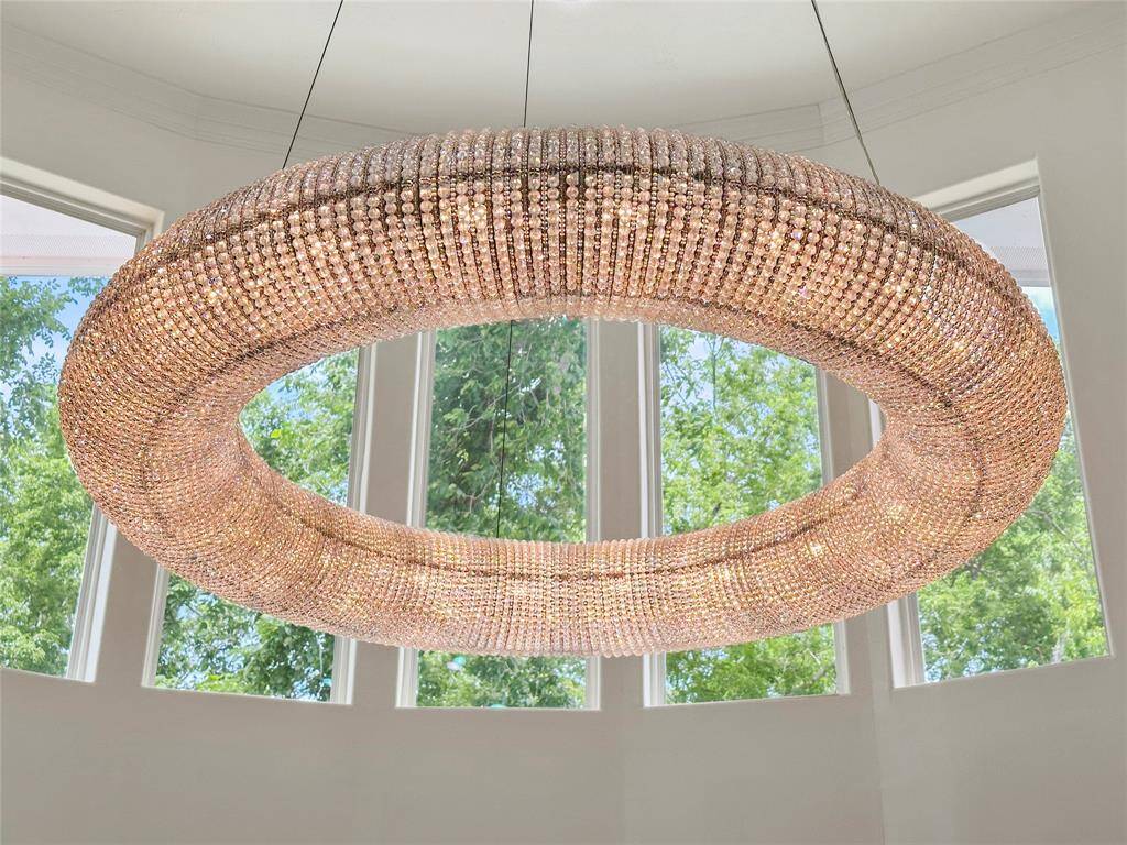 A glamorous chandelier hangs elegantly from the ceiling, casting a warm, sparkling glow across the entire living room.