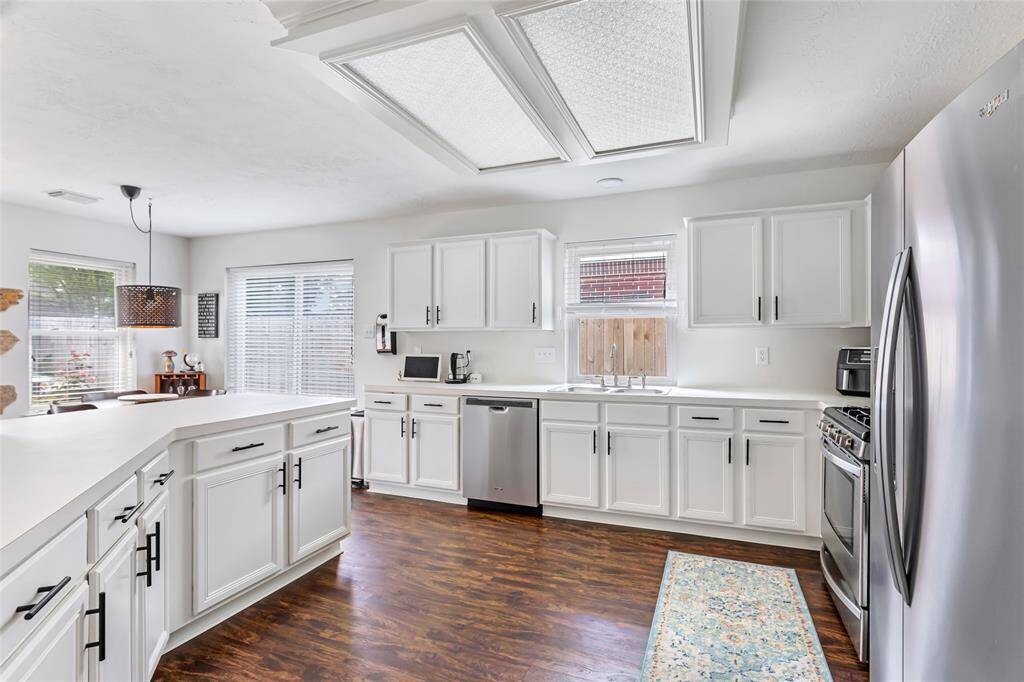 Spacious kitchen with luxury vinyl plank flooring, updated cabinetry hardware, stainless appliances & ample counter space