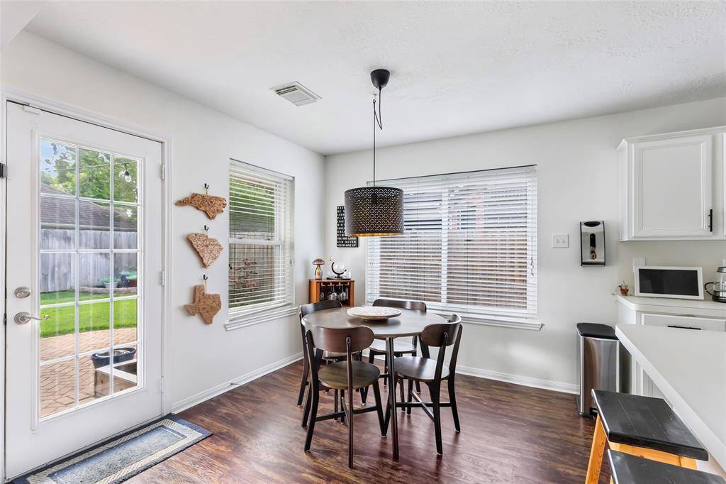 Cute breakfast area with updated light fixture, luxury vinyl plank flooring, updated windows, and bar seating