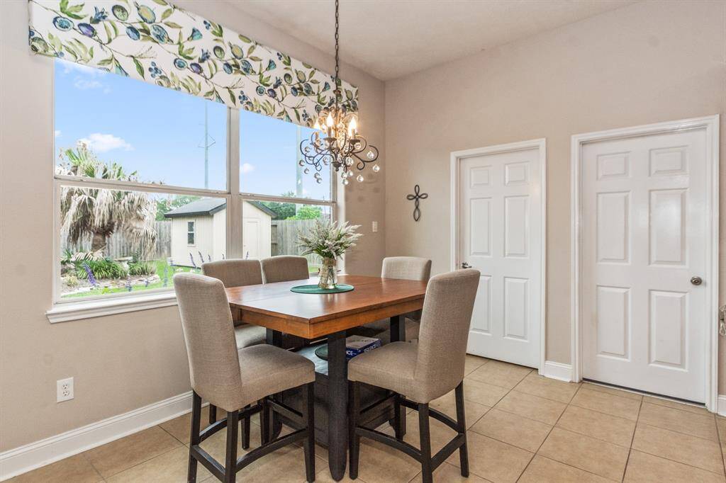 Bright breakfast dining area featuring a large window with garden views and welcoming atmosphere.