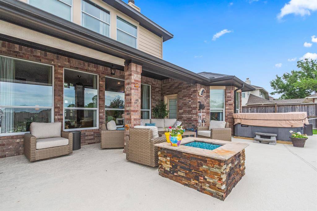 The area is perfect for entertaining, featuring a built-in grill and attractive stone accents. Large windows provide a view into the stylish interior, enhancing the home's appeal.