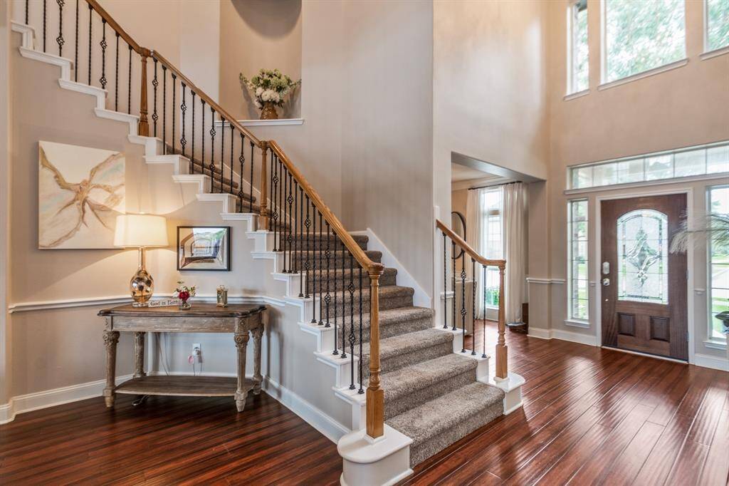 Beautiful welcoming foyer with high ceilings and abundant natural light. A stylish console table and artwork add charm to the space.
