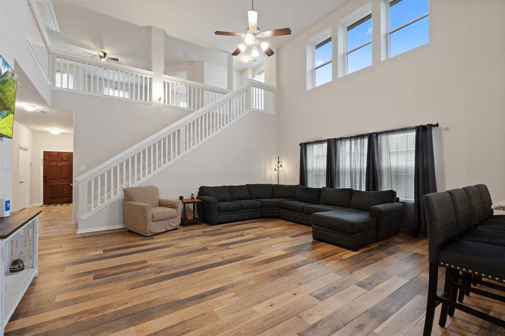 Grand two-story living area with striking wood-look flooring