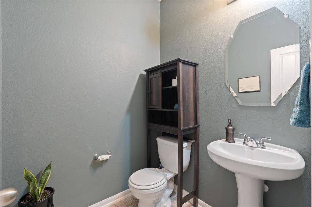 Convenient half bath with stylish pedestal sink, on the main floor