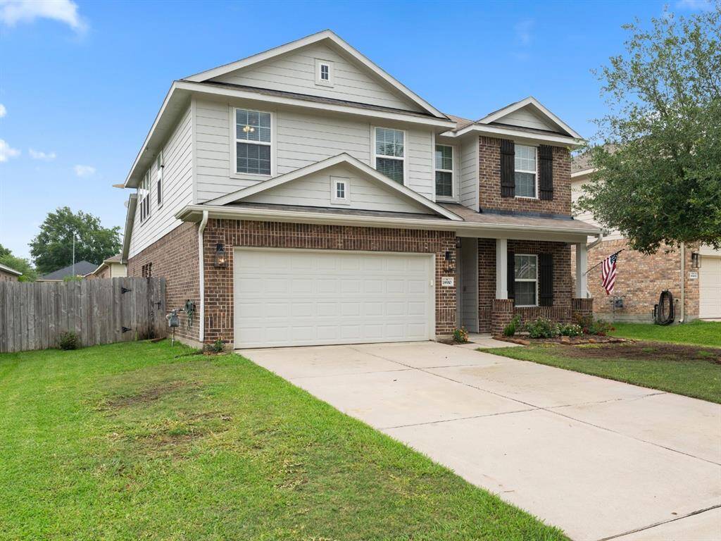 This beautiful brick and siding home boasts a spacious driveway, charming front porch