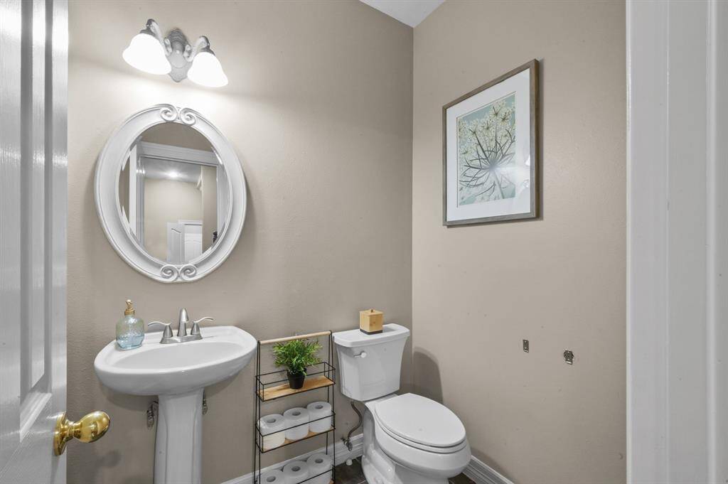 The half bath is conveniently located on the first floor, complete with pedestal sink and custom mirror